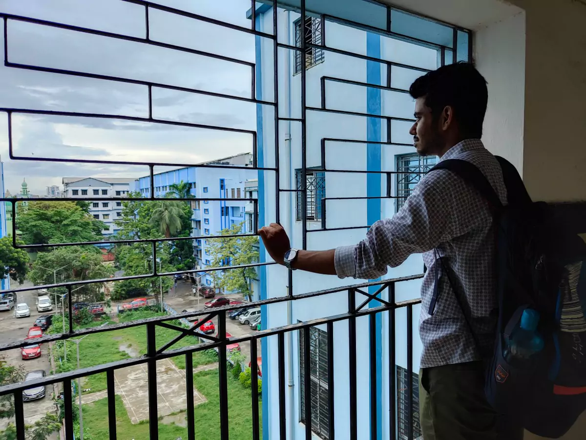 Riazul looking outside from college balcony